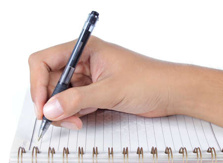 man's hand writing on a book