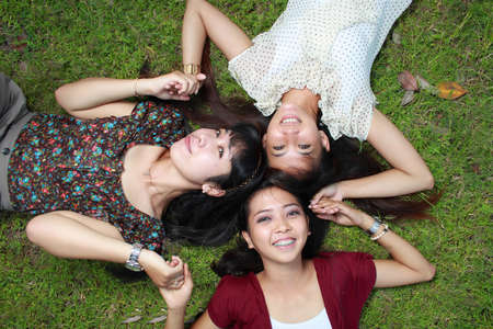 young asian woman lying down with friendsの写真素材