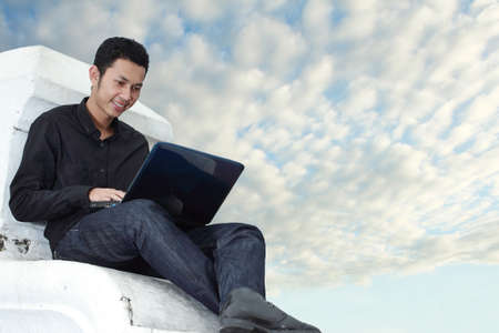 Man using a laptop outdoorsの写真素材