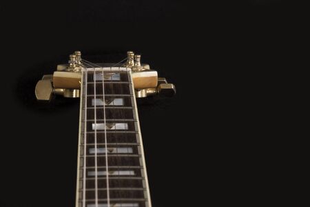 Vintage archtop guitar in natural maple close-up high angle view on black background, rosewood...