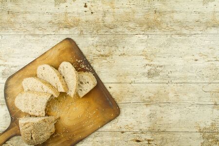 Close-up of a sliced loaf of homemade bread with sesame seeds, a