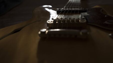 Vintage archtop guitar in natural maple close-up back light high angle viewの写真素材