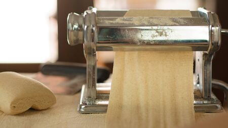 Making homemade fresh pasta: backlit close up of the details of the pasta rolled out by the metal...