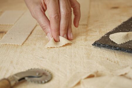 Close up macro detail of process of homemade vegan farfalle pasta with durum wheat flour. The cook...