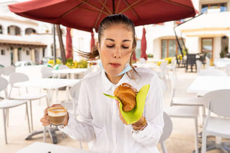 Beautiful fashionable blonde woman has breakfast outdoors