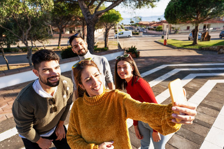 Two millennial couple posing making a self portrait at the sunset or dawn light in the city square -...