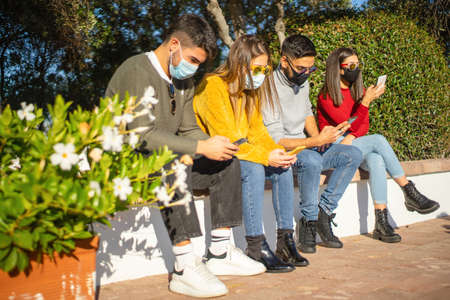 New normal social distancing for people in urban activities: group of millennial sitting on a city...
