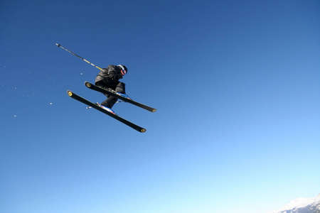 A skier in a business-like pinstripe suit flies through the air in Whistler, BC.の写真素材