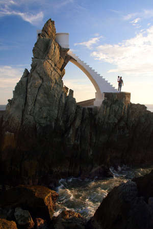 A man holds his child at the base of a dramatic stircase.の写真素材