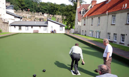 A group of men lawn bowling on a sunny scottish day.の写真素材