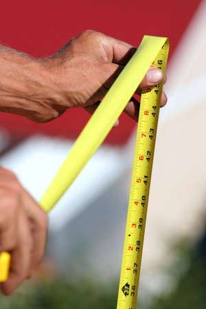 A carpenter holds a tape measure.の写真素材
