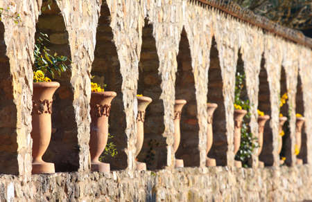 A wall with a series of flower pots in arches.の写真素材