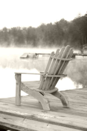 An Adirondack chair sits on a dock in Old Forgr, NY.  Softened and dreamy.の写真素材