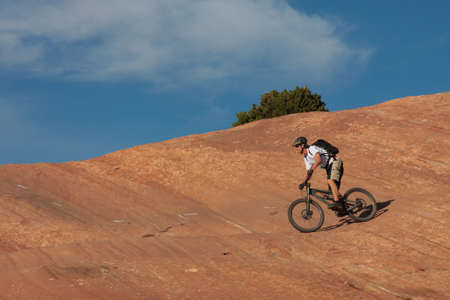 A skilled mountain biker on a red sandstone face.の写真素材