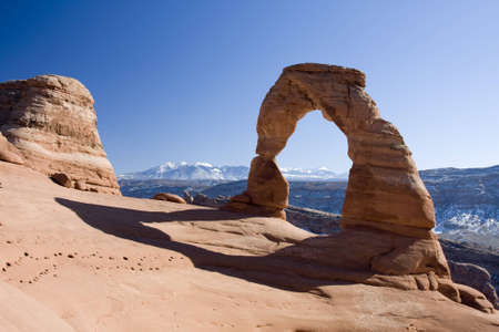 Delicate Arch stands proudly in the foreground as the La Sal mountains loom in the background.