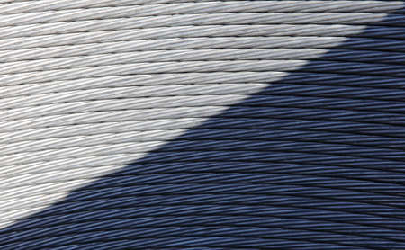 Coils of braided steel cable with a diagonal shadow.の写真素材