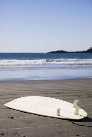 A surfboard sits on a remote Pacific beach near Tofino on British Columbia's west coast.の写真素材