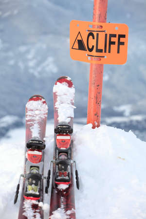 A pair of skis on the edge of a dangerous cliff in Whistler, British Columbiaの写真素材