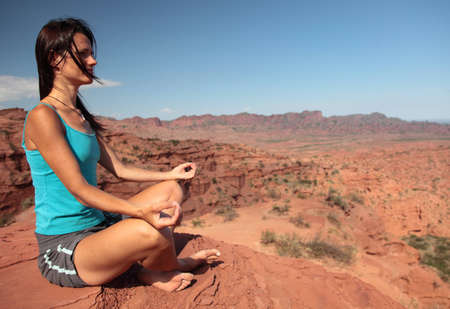 A young woman meditates in a desert in Argentina.の写真素材