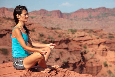 A young woman meditates in a desert in Argentina.の写真素材