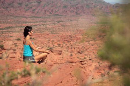 A young woman meditates in a desert in Argentina.の写真素材