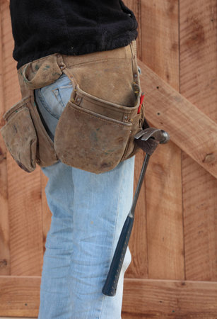 A carpenter stands in front of a wooden door she has just finished building の写真素材