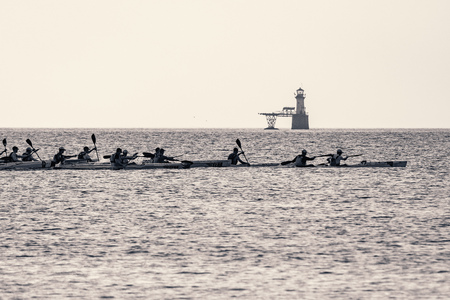 Ocean kayakers paddle their surfskis past Roman Rock lighthouse in South Africa