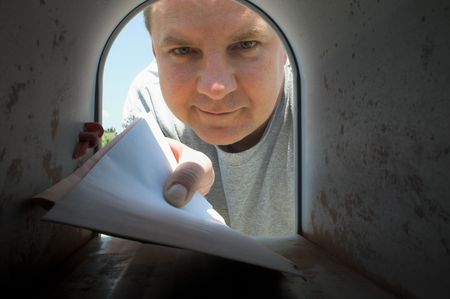 A mailman delivering mail to a mailbox. の写真素材
