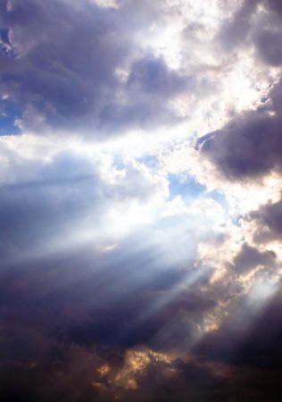 A series of sunbeams shining through storm clouds.