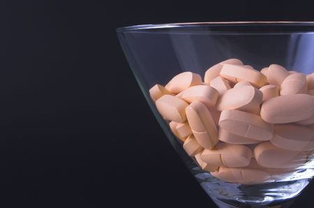 Pills in a martini glass - Drug abuse concept.の写真素材
