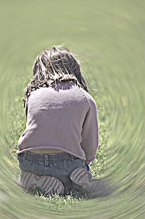 A little girl playing in the grass.の写真素材