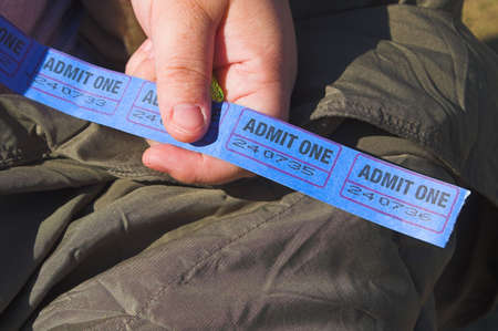 A person holding a string of admission tickets.の写真素材
