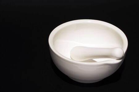 A porcelain mortar and pestle used for pulverizing pharmaceutical ingredients or food preparation.の写真素材