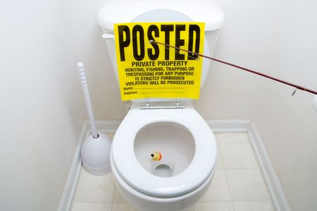 A posted sign on the back of a toilet.の写真素材
