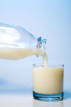 Pouring milk into a glass ready for consumption.の写真素材