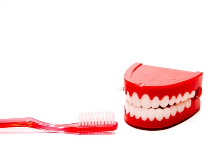 A toothbrush and a set of chattering teeth in a glass.