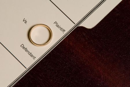 A folder for a divorce case with a wedding ring.の写真素材