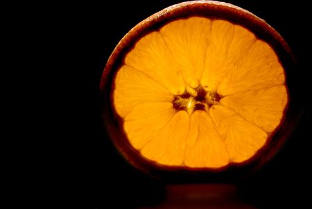 A fresh orange slice in the dark.の写真素材