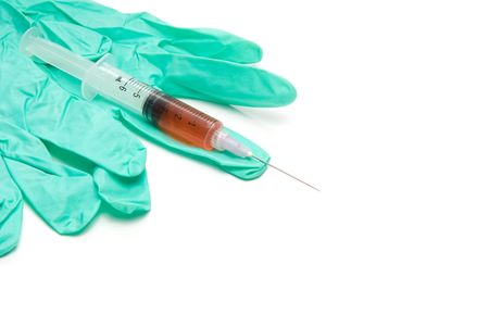 A medical syringe with latex free gloves.の写真素材