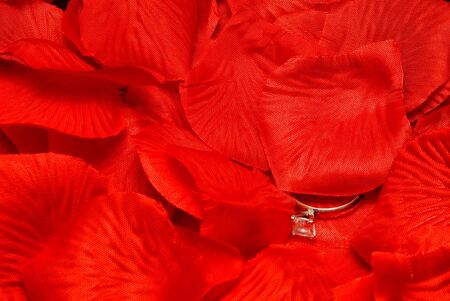 A diamond wedding ring on a fake rose petal.の写真素材