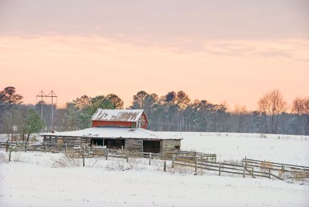 An old horse barn and corral in the snow.の写真素材