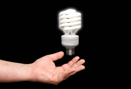 A florescent light bulb floating above a hand.