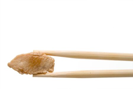 A piece of asian style pork being held by chopsticks.の写真素材