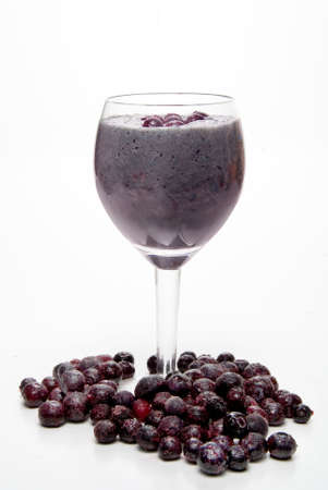 A Blueberry Smoothie surrounded by frozen blueberries.の写真素材