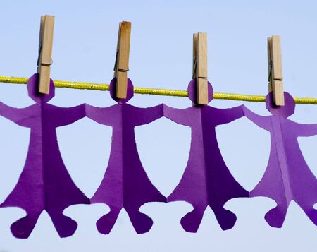 Paper dolls clipped to an outside clothesline.の写真素材