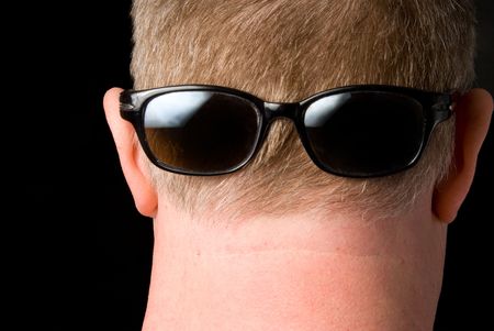 A man wearing sunglasses backwards on his head.の写真素材
