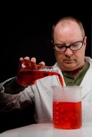 A Scientist pouring a solution into a beaker.の写真素材