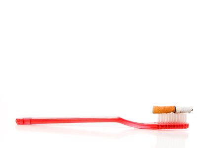 A used cigarette butt on top of a toothbrushの写真素材