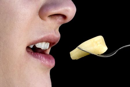 A young beautiful Woman Eating Peaches with a forkの写真素材