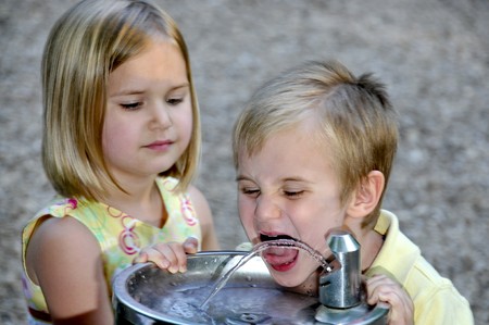 A little boy drinking water at a playgroundの写真素材